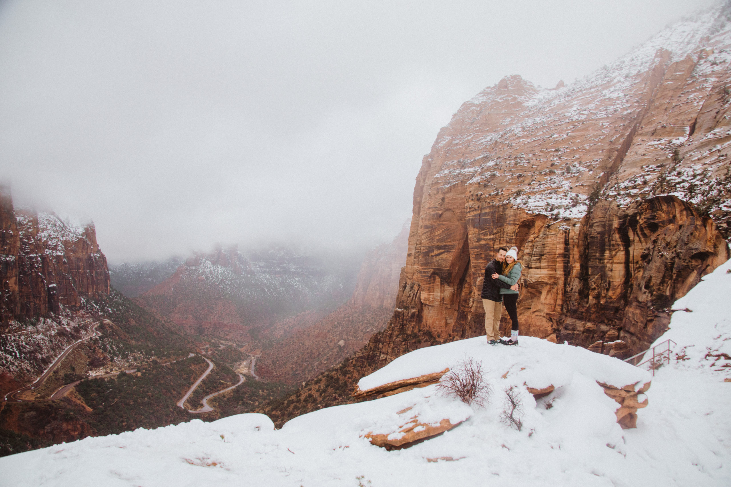 couple standing in zion in the snow
