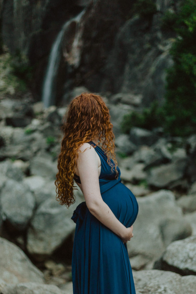 pregnant woman standing with arm on belly